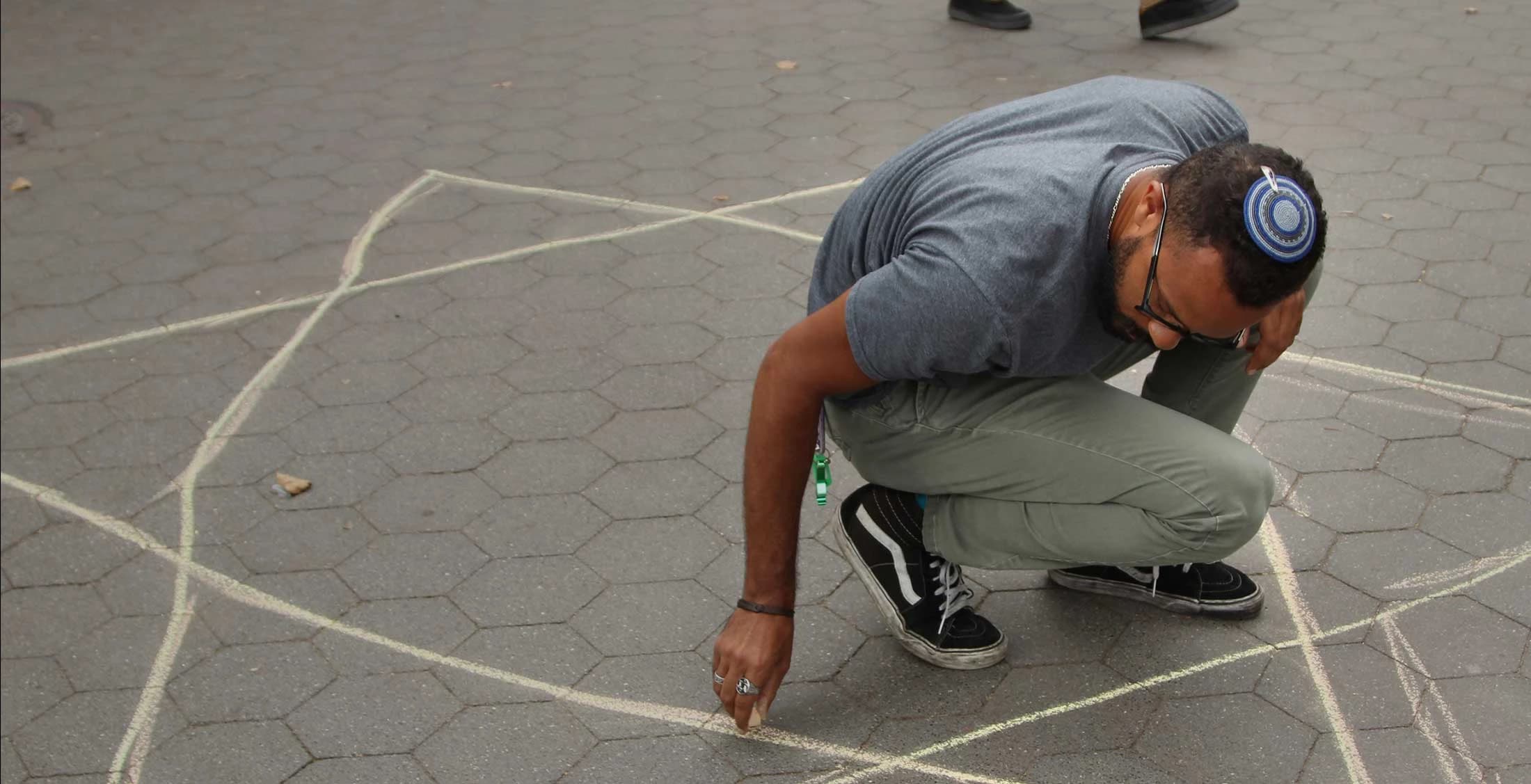 man drawing a star of david