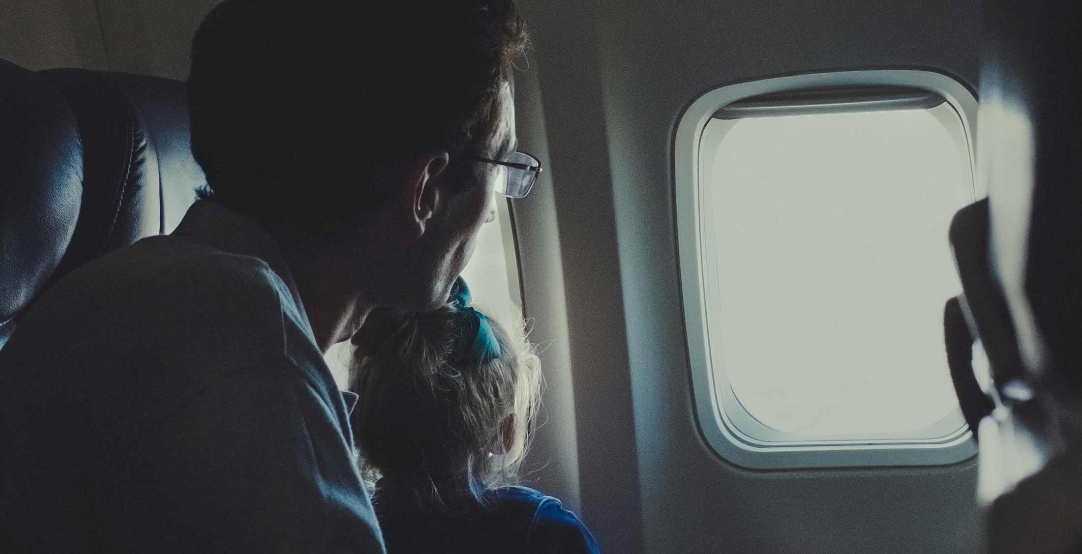 Jewish father and son looking out the window of an airplane.